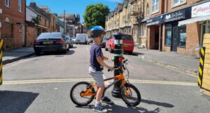 High Court Throws Out 039 Not Viable 039 Attempt To Block Congestion Charge A small child on a bicycle looking down a street made safe with a bollard and planters. The bollard is decorated with fuzzy baubles and he is reaching out to play with them.